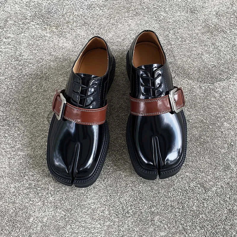 Cross Buckle Leather Tabbi Loafers featuring a unique design with a brown strap and polished black finish.