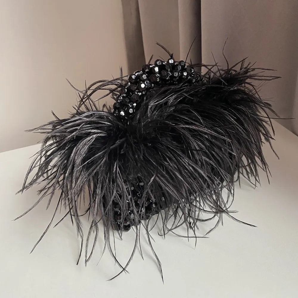 Black feathered headpiece with sequins on a neutral background